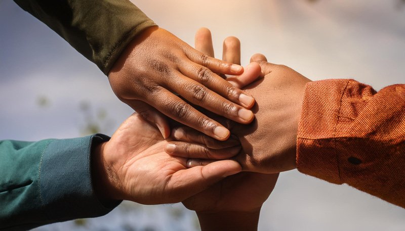 A group of hands joined together, symbolizing unity and support, essential for Nonprofit Organization Websites